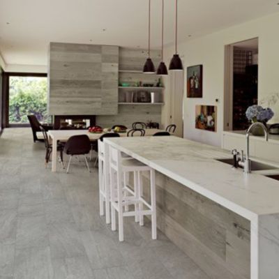 grey tile flooring in a open kitchen with large island and wood accent wall